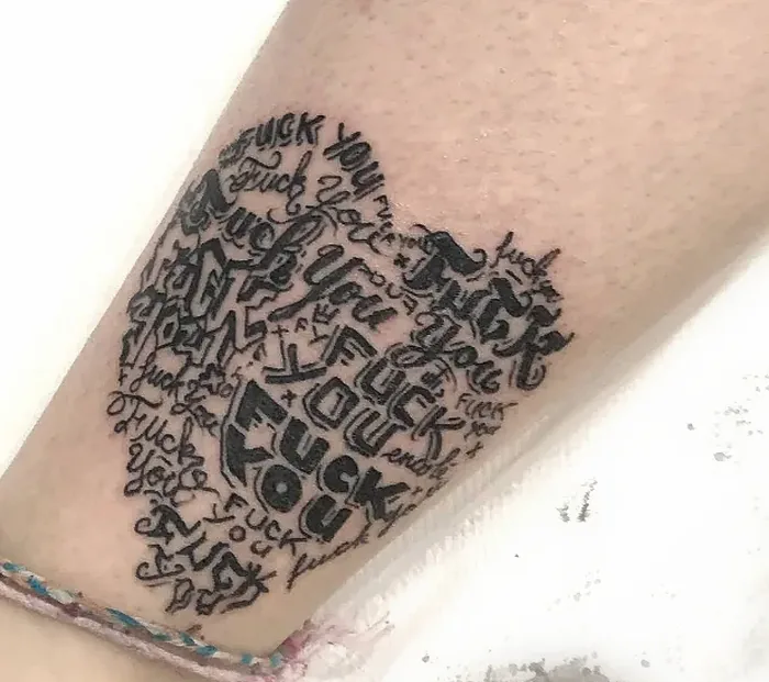 Cœur composé de lettrages graffiti superposés, tatoué sur un mollet
