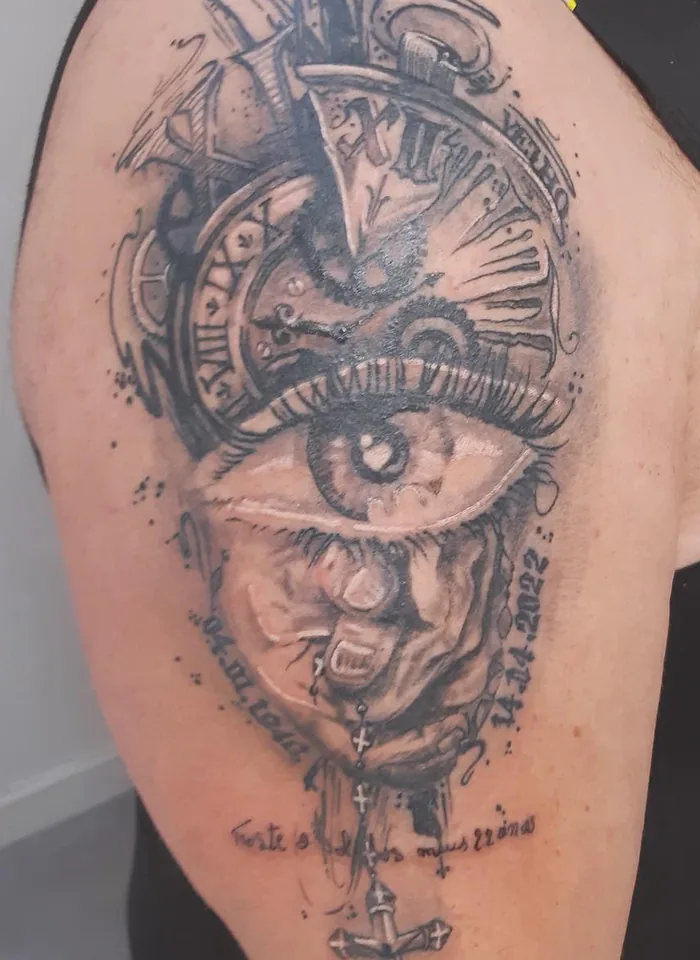 Horloge à chiffres romains et œil en réalisme noir et gris, tatoués sur une épaule, avec chapelet et dates
