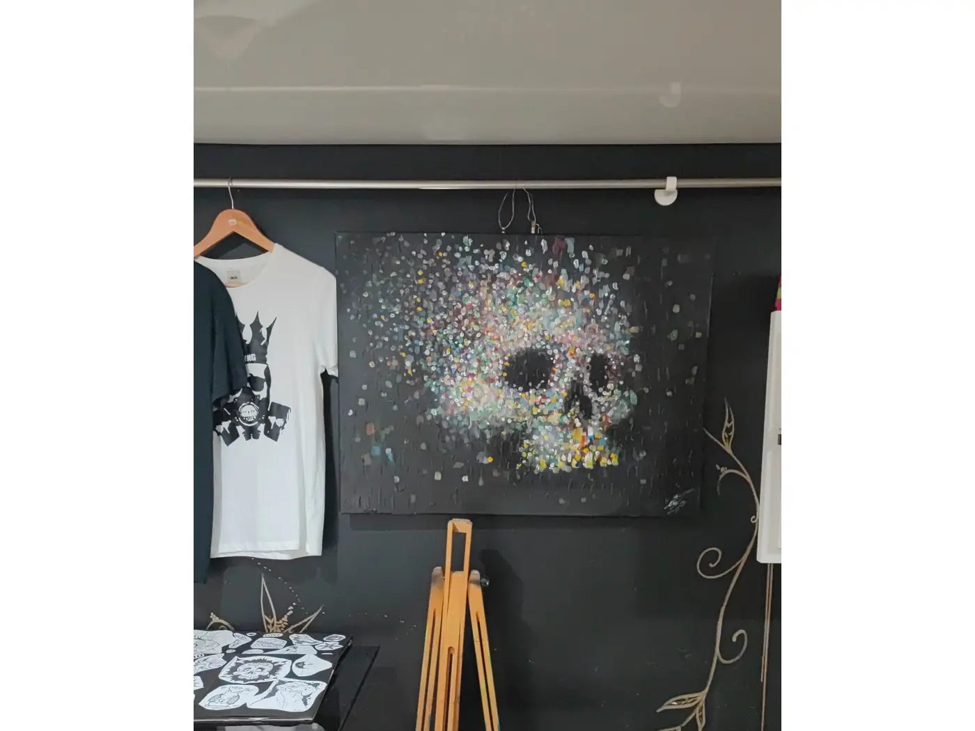 T-shirt Bad King couronne accroché dans l'atelier avec toile crâne pointilliste